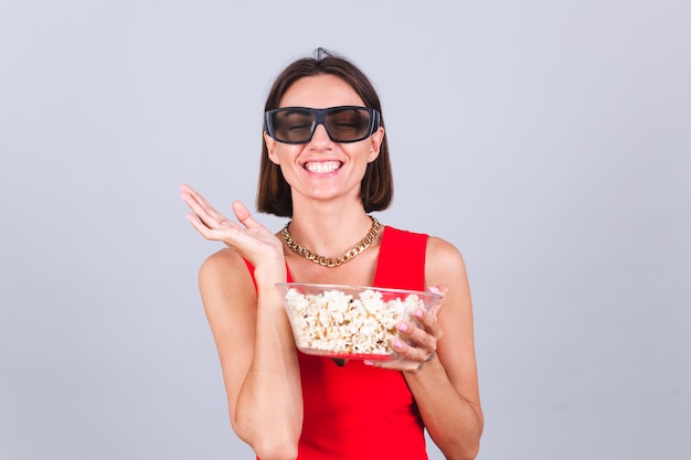 Free Photo beautiful woman on gray wall in 3d cinema glasses with popcorn, cheerful happy positive emotions