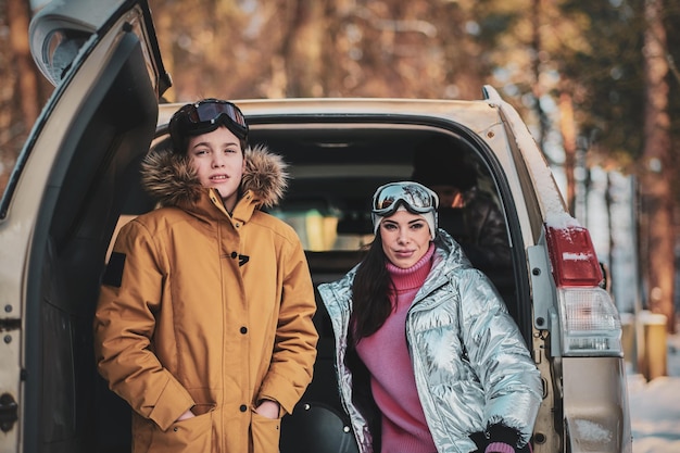 Beautiful woman and her son are posing for photographer while sitting in the car.