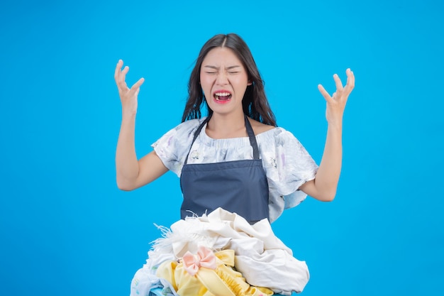 A beautiful woman holding a cloth prepared to wash on blue