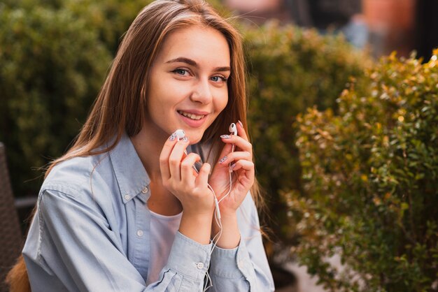 Beautiful woman holding earphones