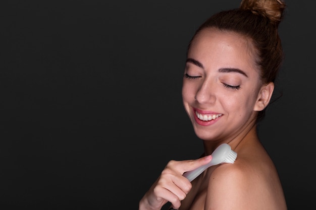 Beautiful woman holding face brush