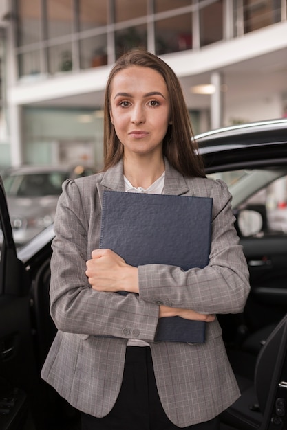 Free photo beautiful woman holding a folder close to her chest