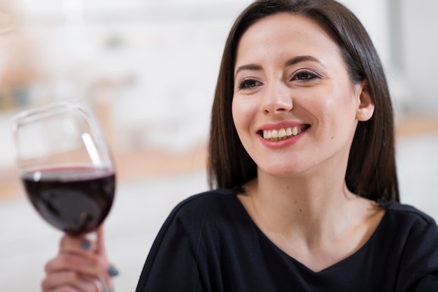 Beautiful woman holding a glass of red wine close-up