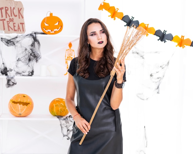 Free photo beautiful woman holding halloween broom