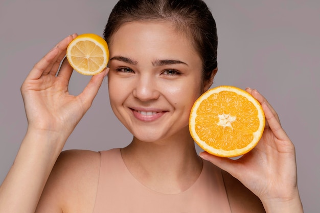 Beautiful woman holding halved orange