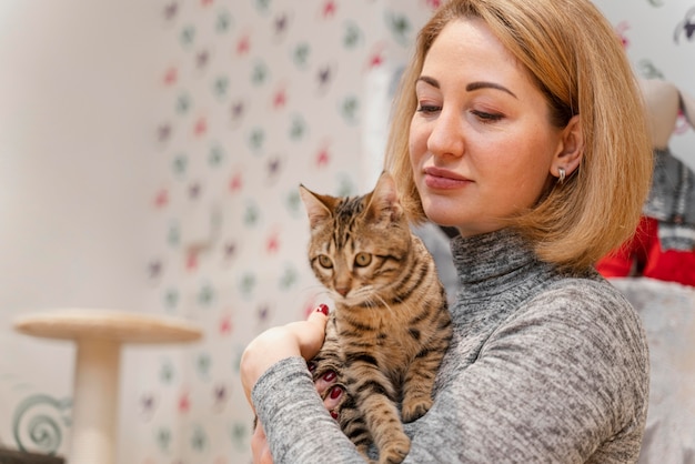 Free Photo beautiful woman holding a kitty at the pet shop