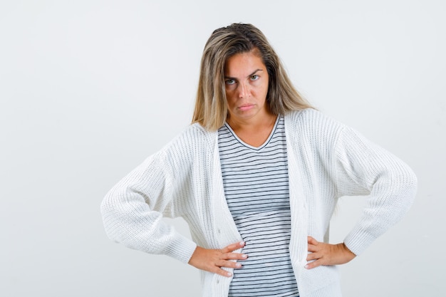 Free photo beautiful woman in jacket holding hands on waist and looking displeased , front view.