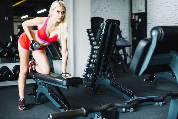 Beautiful woman lifting small dumbbell