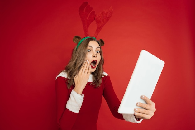 Free Photo beautiful woman like christmas deer isolated on red wall concept 