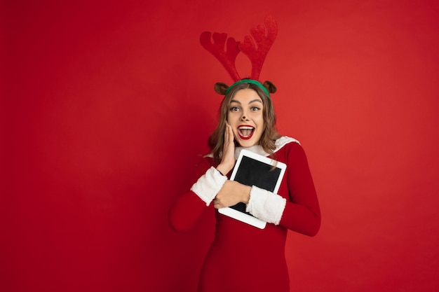 Free Photo beautiful woman like christmas deer isolated on red wall concept 