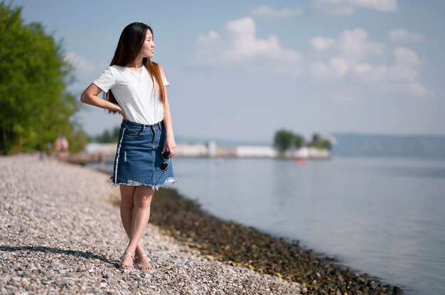 Beautiful woman looking away on the beach with copy space