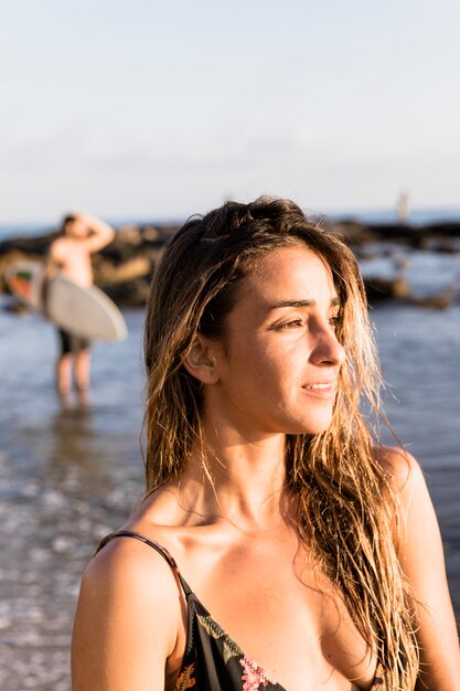 Beautiful woman looking away near sea