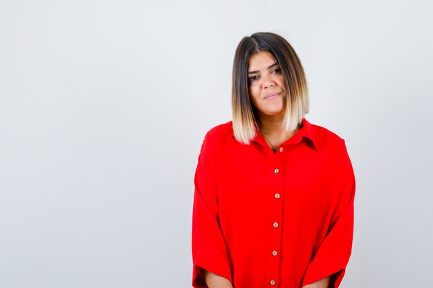 Beautiful woman looking at camera in red blouse and looking delicate , front view.