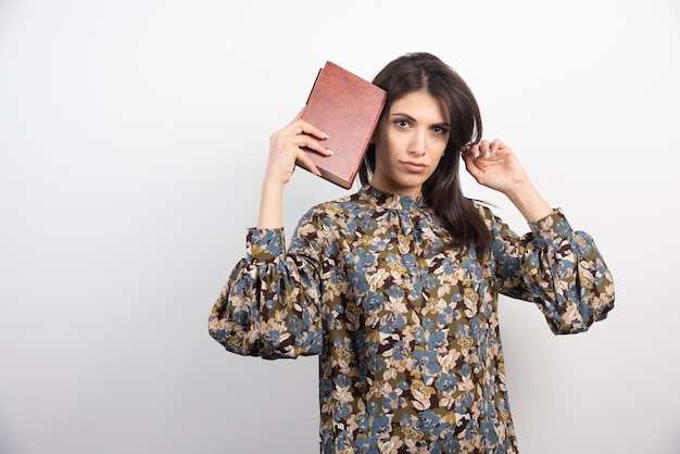 Beautiful woman looking at camera with book.