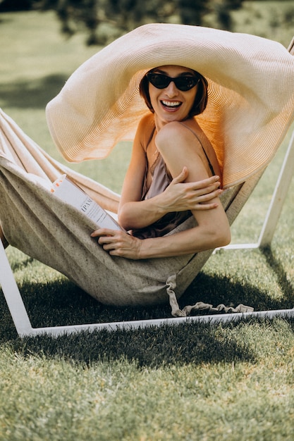 Free Photo beautiful woman lying in hammock wearing big sunhat