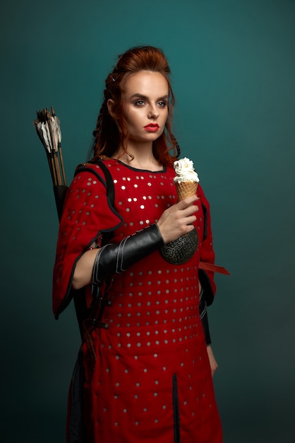 Beautiful woman in medieval costume holding ice cream.