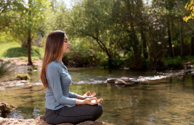 Beautiful woman meditating in nature