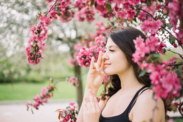 Beautiful woman meditation with mudra gesture near tree in garden