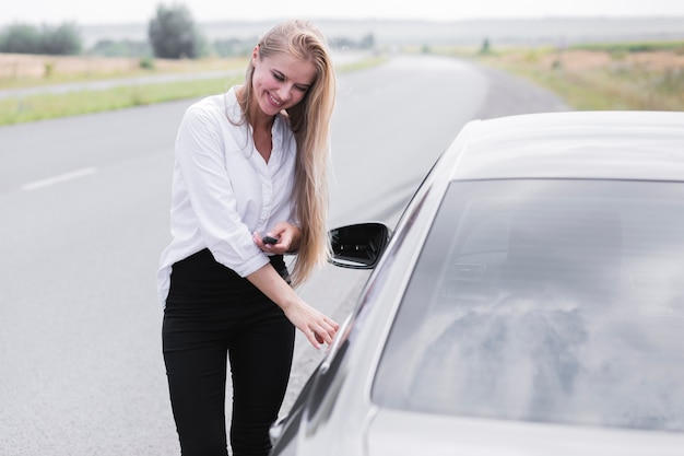 Beautiful woman opening the door of the car