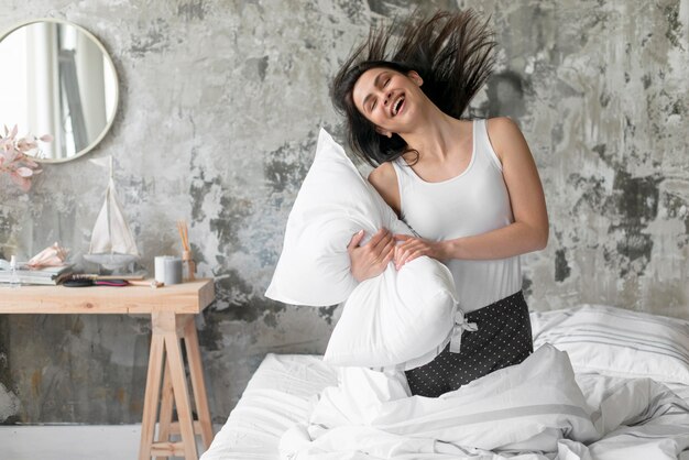 Beautiful woman playing with pillow