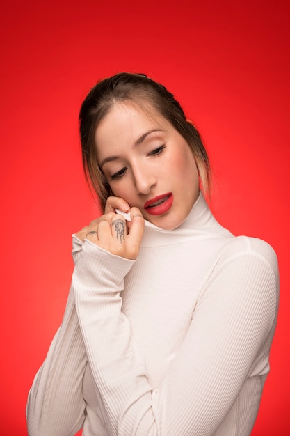 Beautiful woman posing on red background