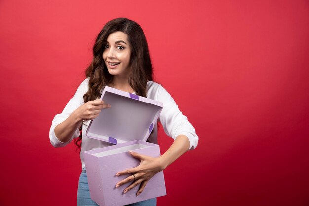 Beautiful woman posing with purple present box. High quality photo