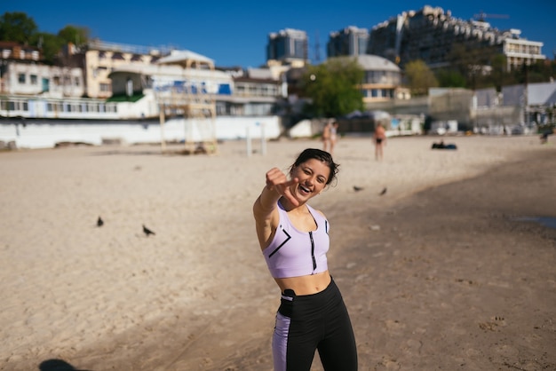 Free photo beautiful woman in a public beach after training with sporty look