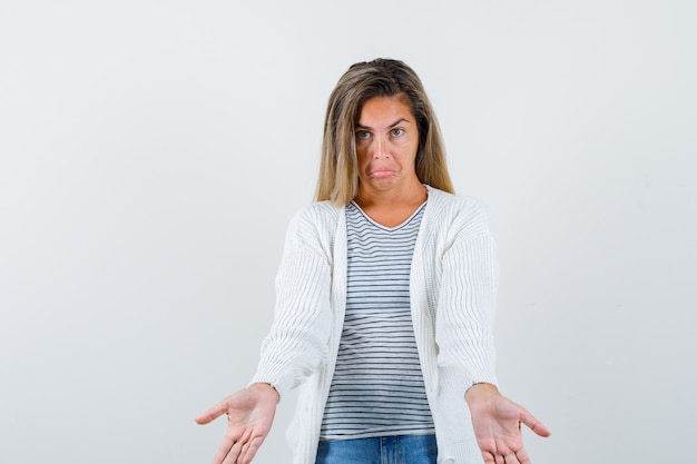 Free Photo beautiful woman reaching hands at camera in jacket and looking puzzled , front view.