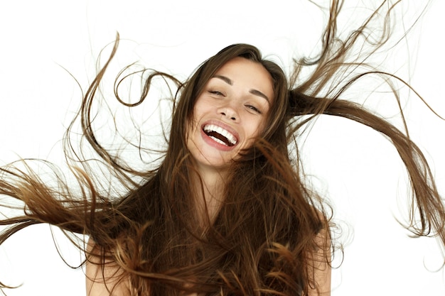 Free photo beautiful woman shakes her hair on white background