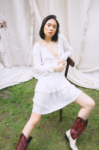 Free photo beautiful woman sitting on a chair in garden .