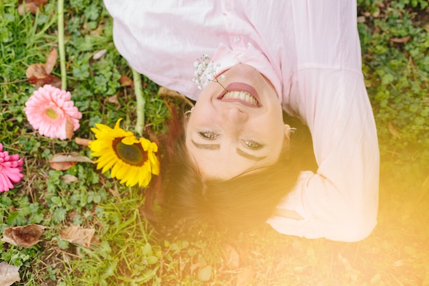 Free photo beautiful woman smiling and lying on grass