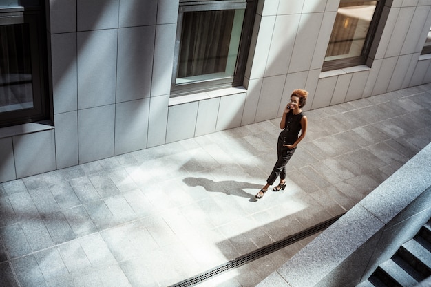 Beautiful woman smiling talking on phone walking down city