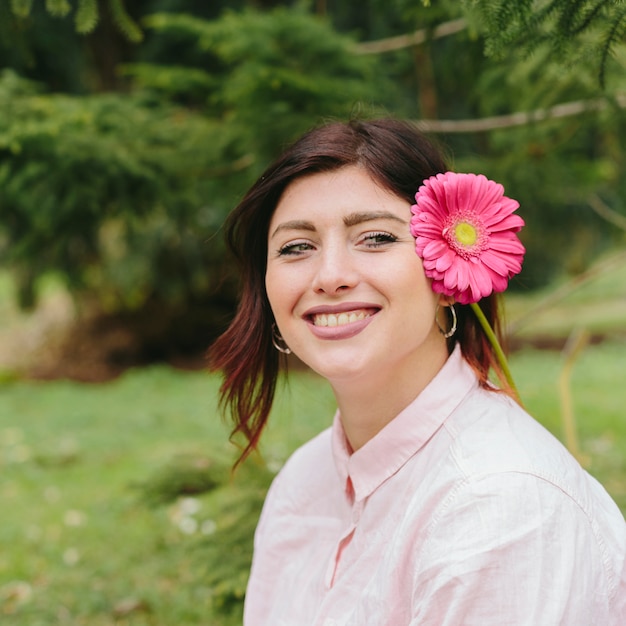 Beautiful woman smiling with flower in hair