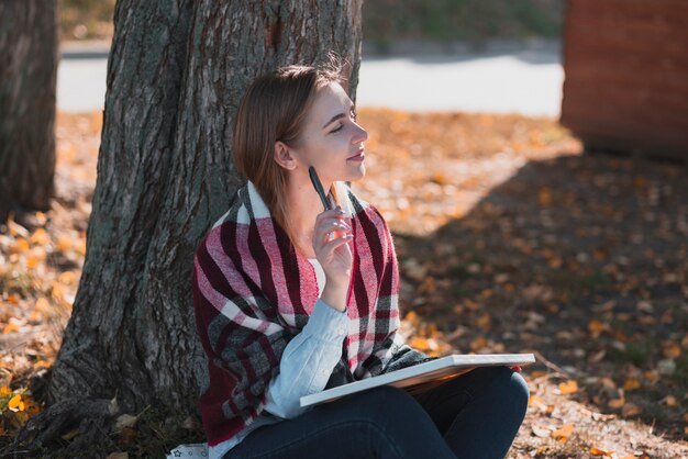 Beautiful woman standing  near a tree