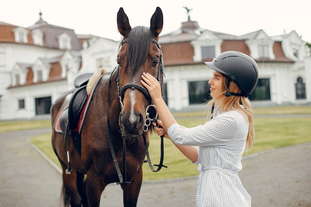 Beautiful woman standing with a horse