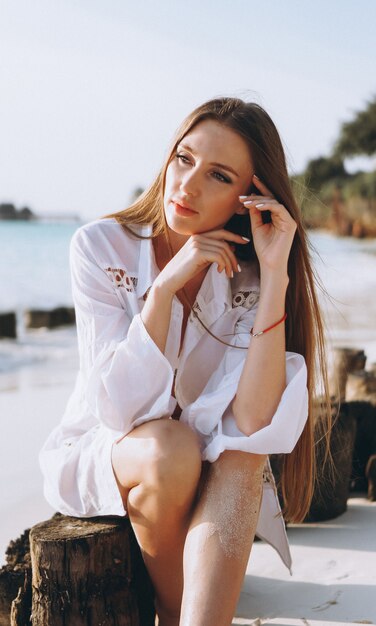 Beautiful woman in swim wear sitting by the ocean