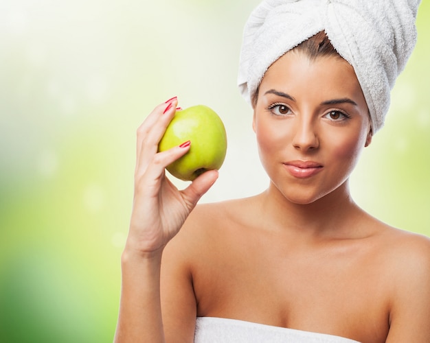 Free photo beautiful woman in towel holding green apple