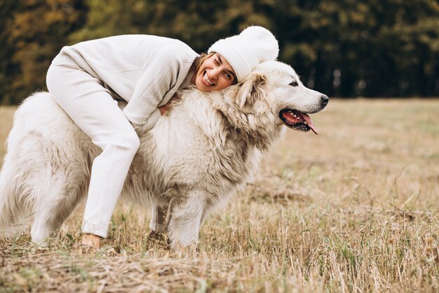 Beautiful woman walking out her dog in a field