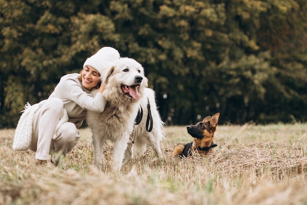 Free Photo beautiful woman walking out her dogs in a field