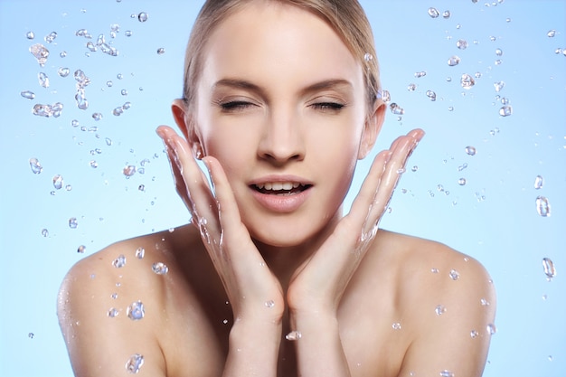 Free Photo beautiful woman washing her face