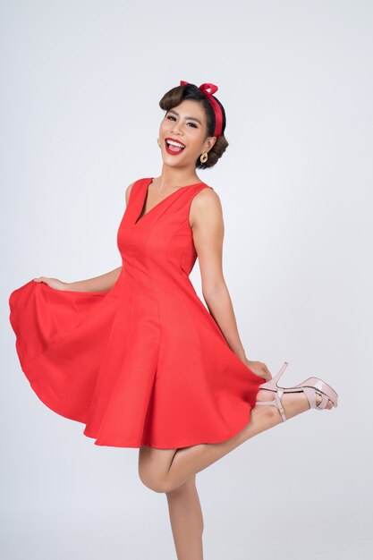 Beautiful woman wearing red dress in studio