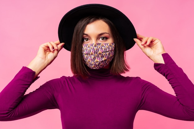 Free photo beautiful woman wearing stylish protective face mask. black hat.