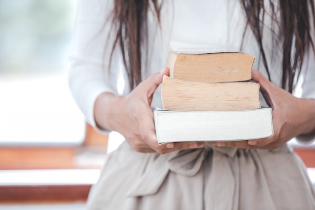 Free photo beautiful woman wearing a white t-shirt holding books