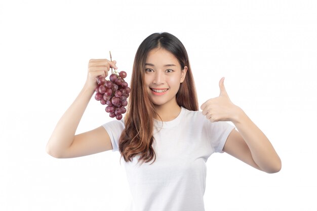 Beautiful woman with a happy smile holding a hand grape, isolated on white background.