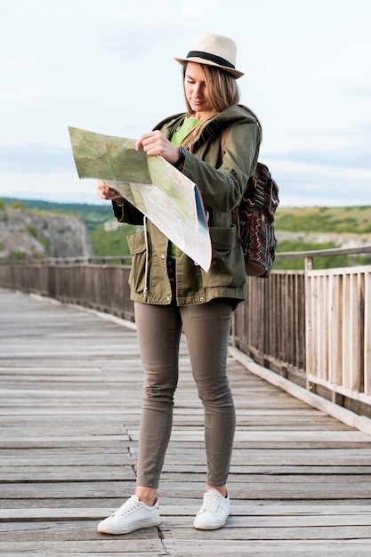 Beautiful woman with hat checking map