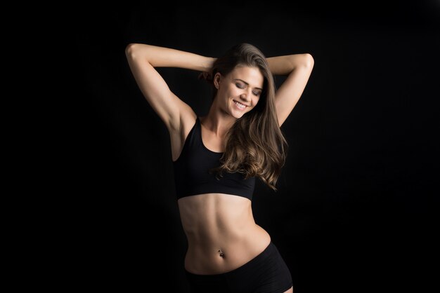 Beautiful woman with healthy body on black background