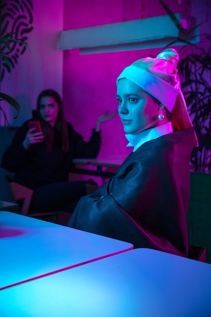 Free photo beautiful woman with a pearl earring taking lunch in modern cafe