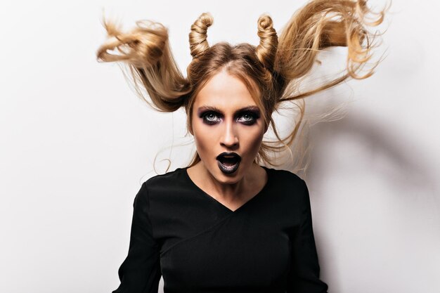 Beautiful woman with shiny hair posing in halloween Indoor photo of cute vampire girl