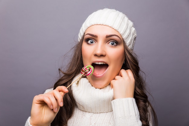 Beautiful woman with white hat holding Lollipop