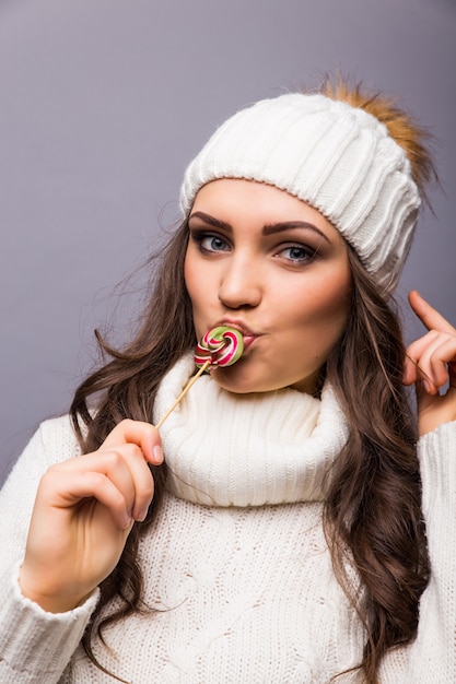 Beautiful woman with white hat holding Lollipop